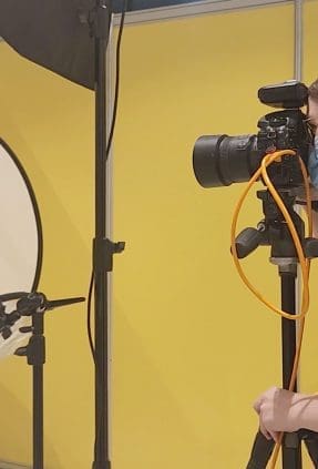 Behind the scenes image of Julia photographing at the small biz expo 2022