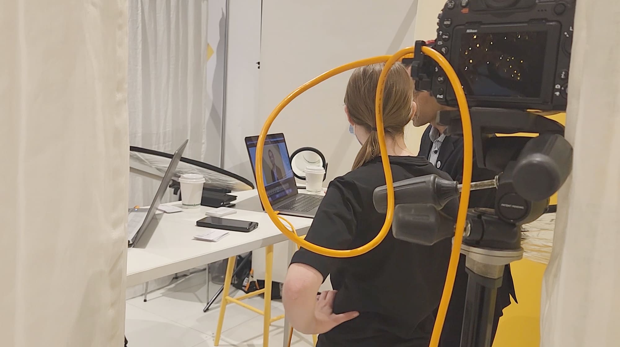 Behind the scenes image of Julia working with a client to review headshots.