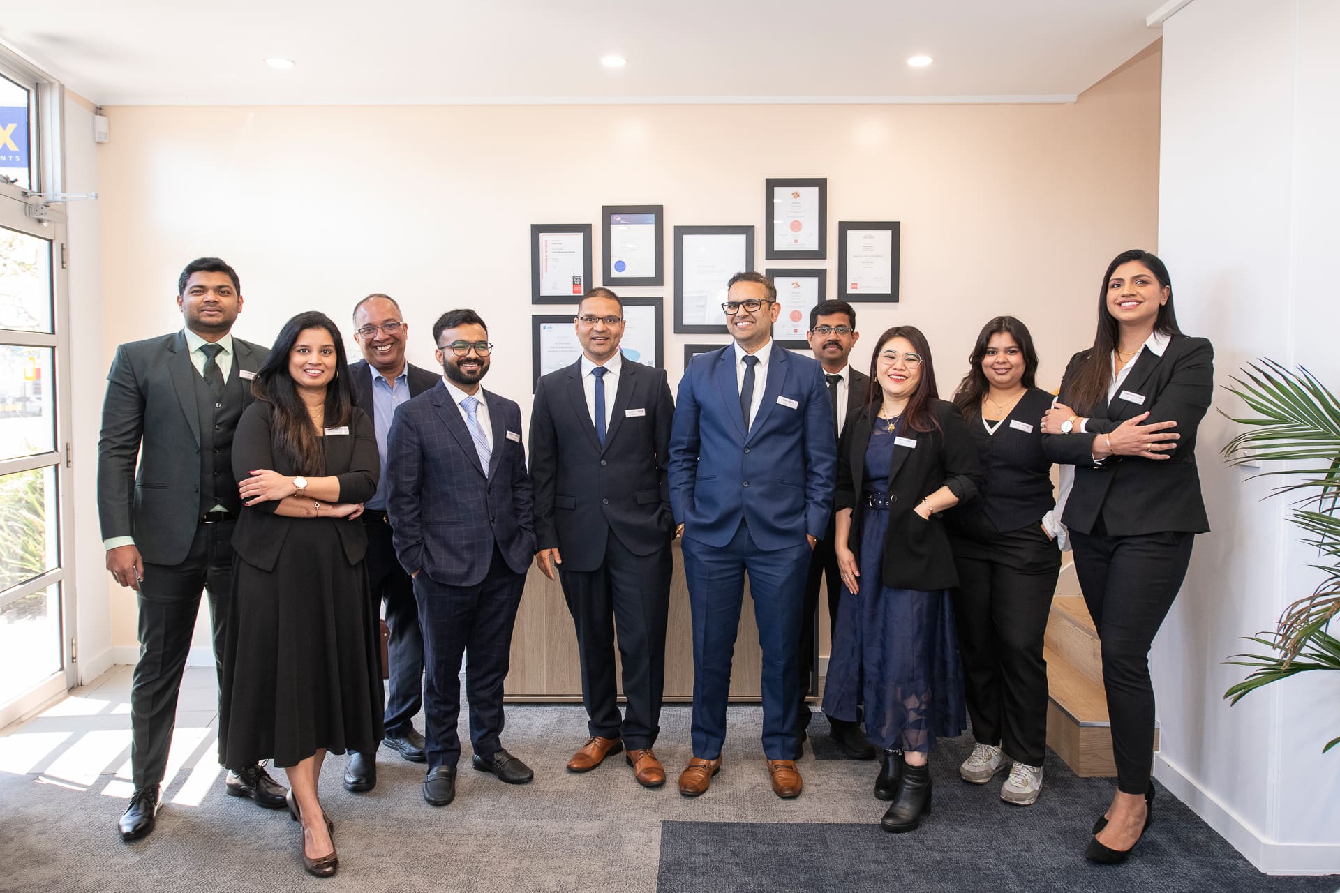 Group team photography within office environment. Business awards are visible in the background.
